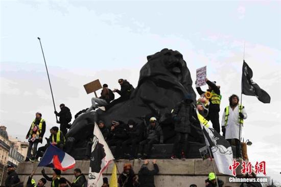 当地时间12月10日，法国遭遇新一轮响应大罢工的示威游行。图为人们在巴黎市中心示威游行。